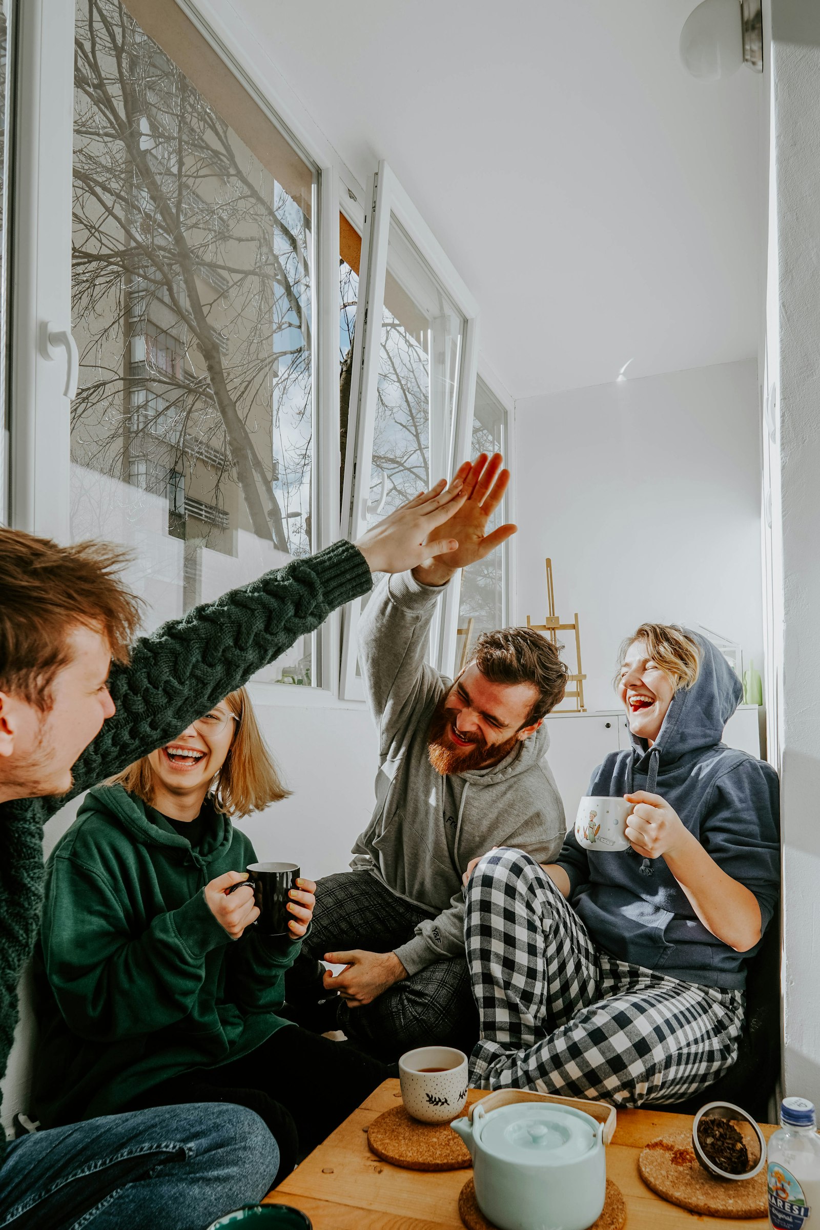 Fyra vänner som skrattar och high-fivear tillsammans
